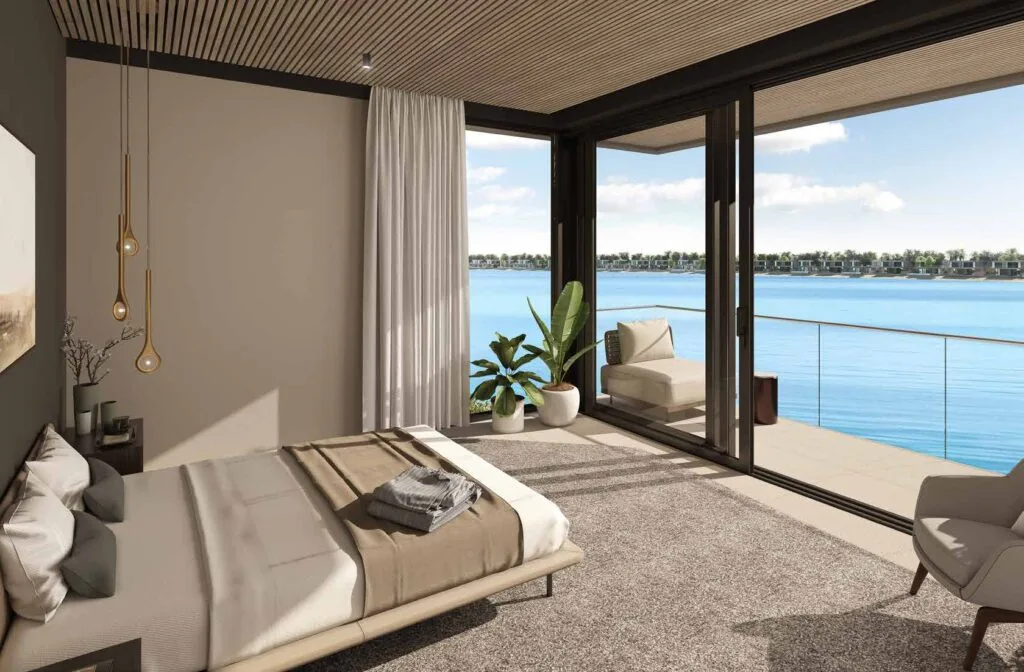 Bedroom interior with large glass doors opening to sea view balcony
