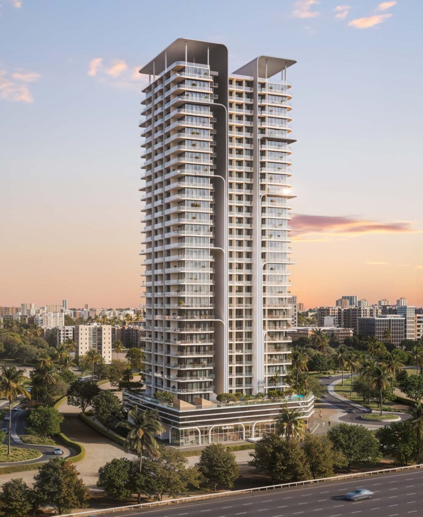 Tall residential tower with balconies and surrounding greenery