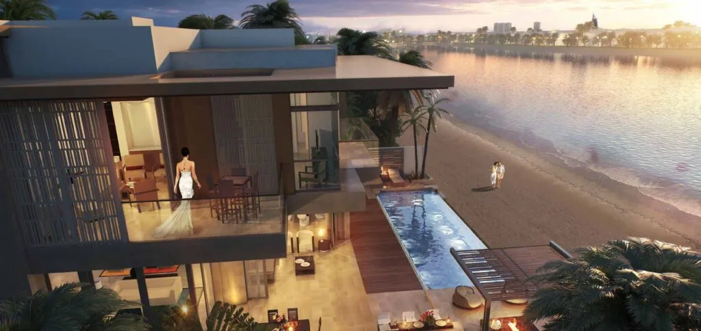 Exterior view of modern villa with pool and beach at sunset