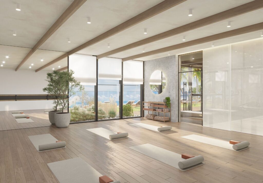 Interior yoga room with mats and large windows overlooking outdoor garden