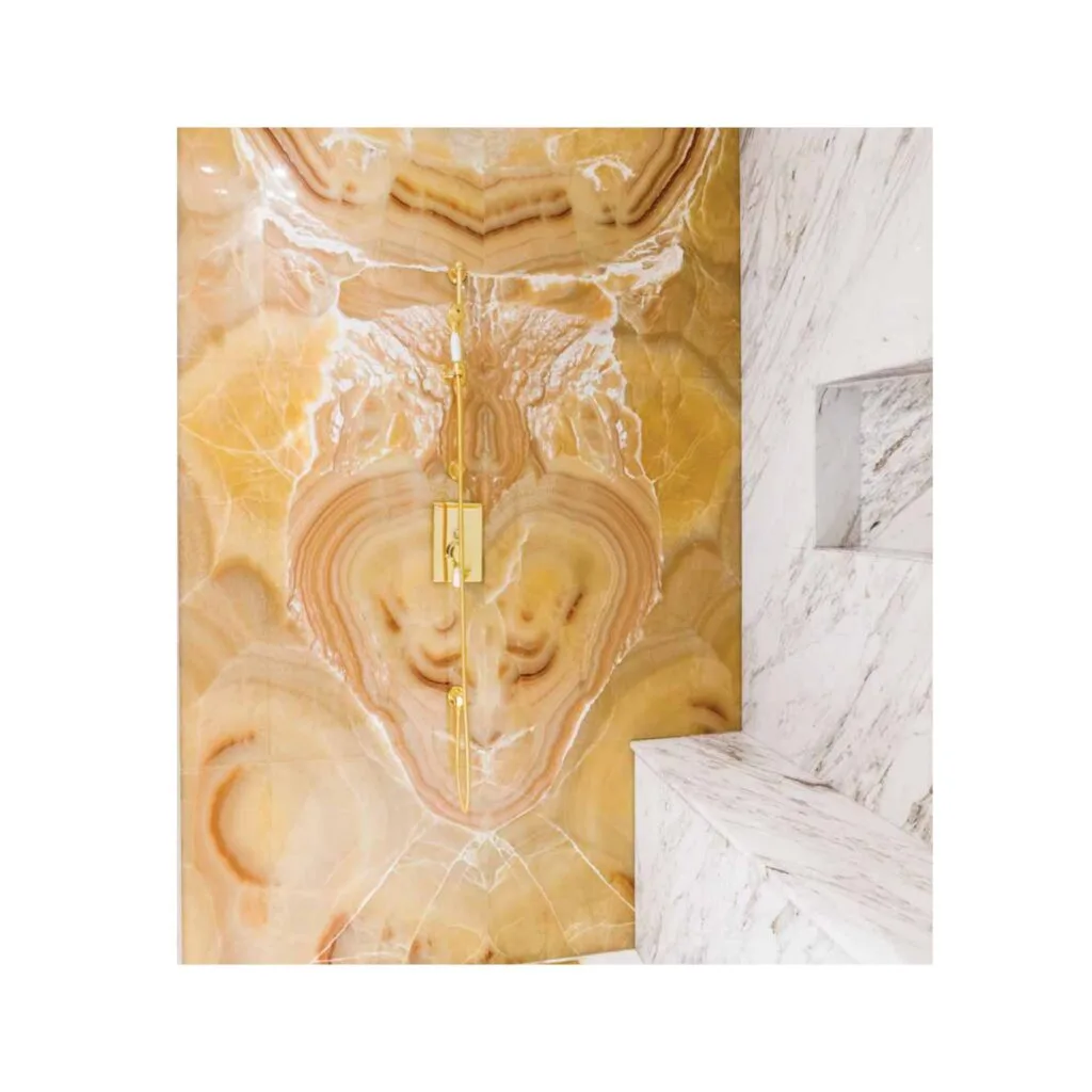 shower area with golden fixtures and marble walls
