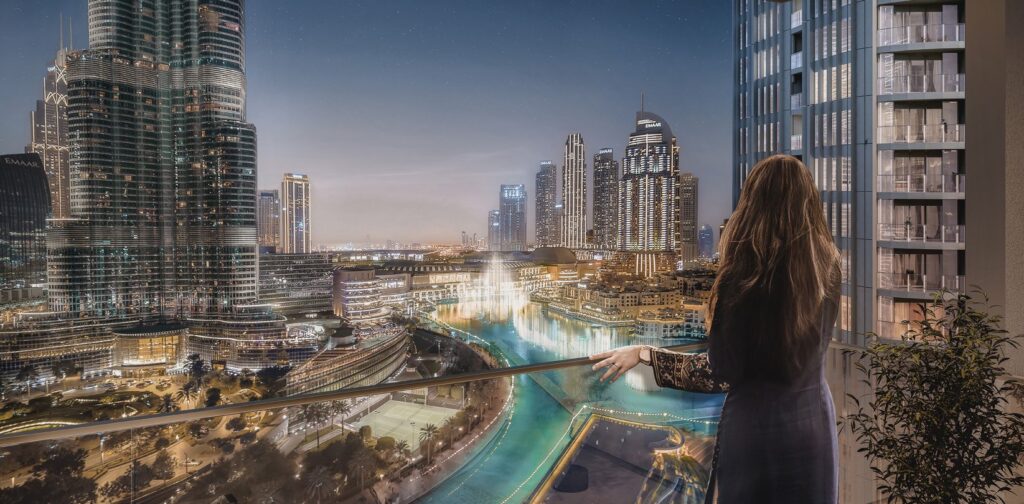 Night view of Dubai cityscape with fountain and high-rise buildings