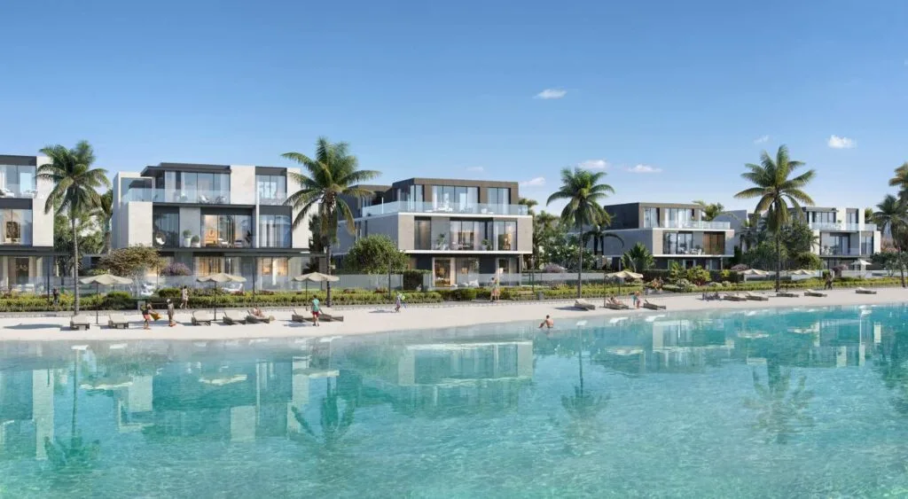Modern low-rise buildings by a large clear water pool with palm trees