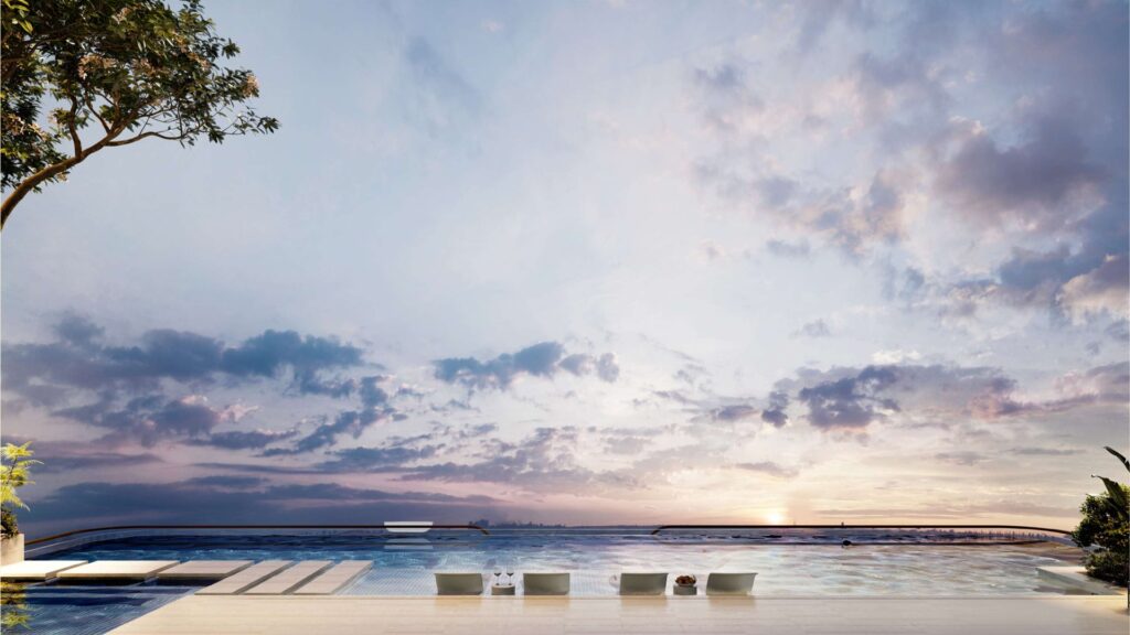 Outdoor swimming pool with seating and sunset sky