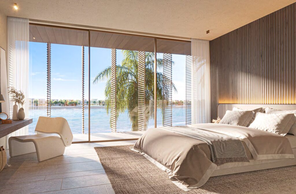 Bedroom interior with large windows showing sea and palm trees