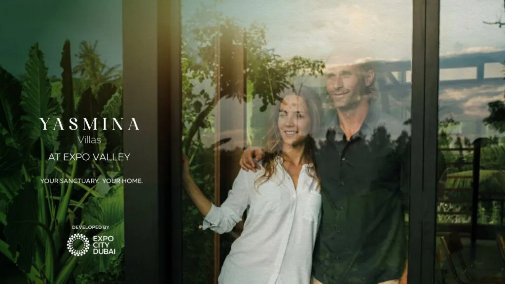 Couple standing inside villa near glass door with garden view